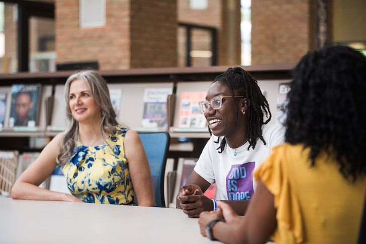 People having a conversation at a table in a library