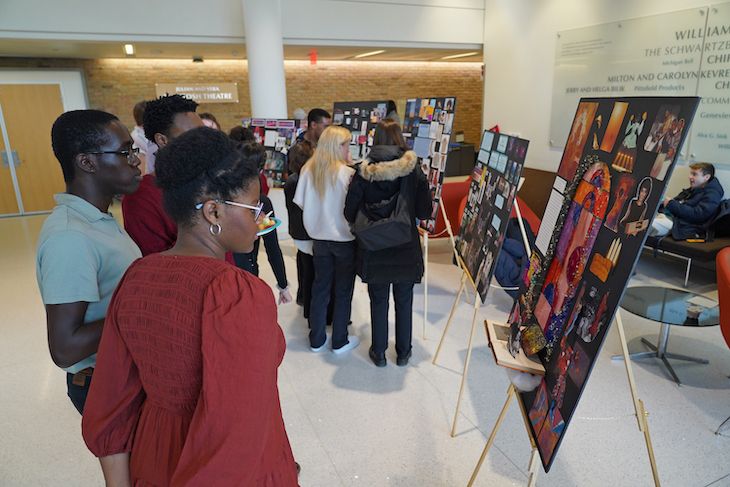 People looking at posters displayed on easels