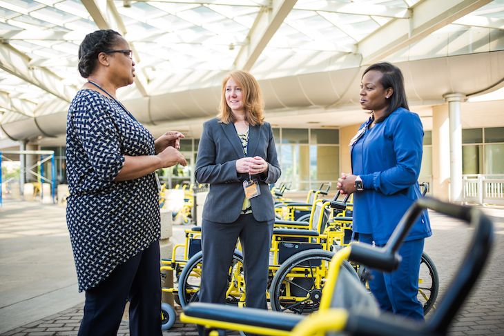 Medical staff having a conversation at the outdoor wheelchair storage