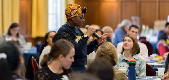 People listening to an audience member speaking into a microphone at an event